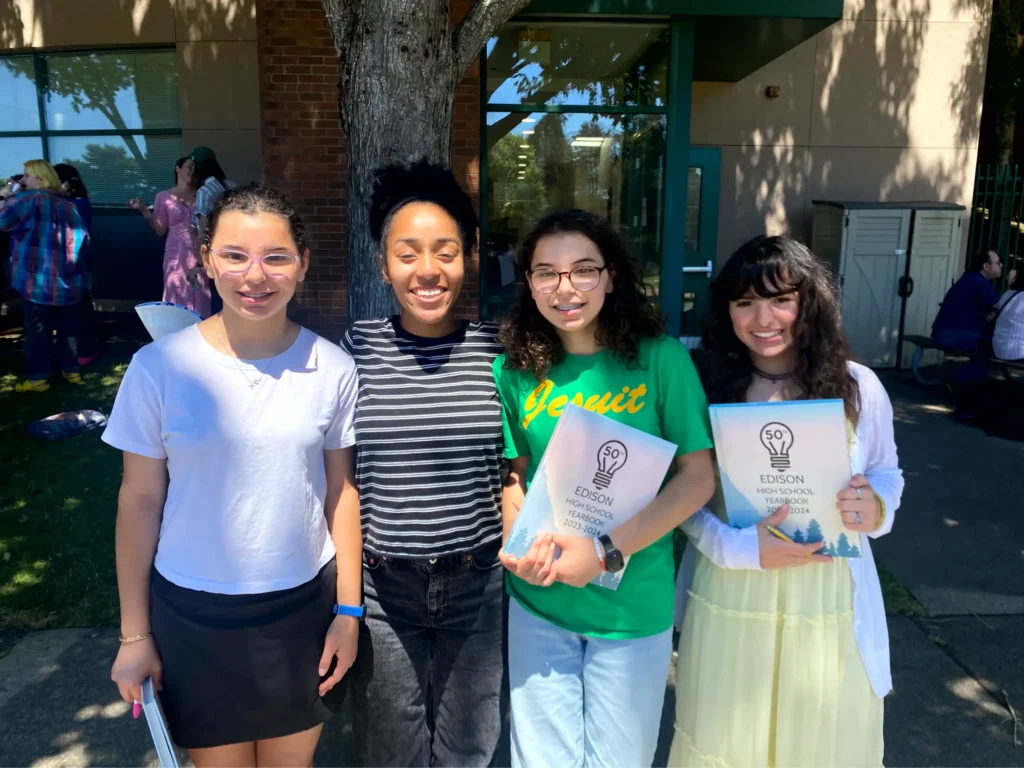 Four students holding Edison High School Yearbooks