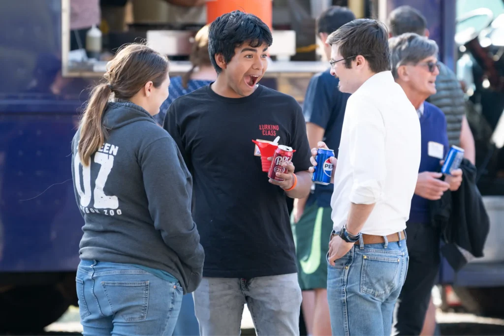 Candid photo - group of three young people and food truck