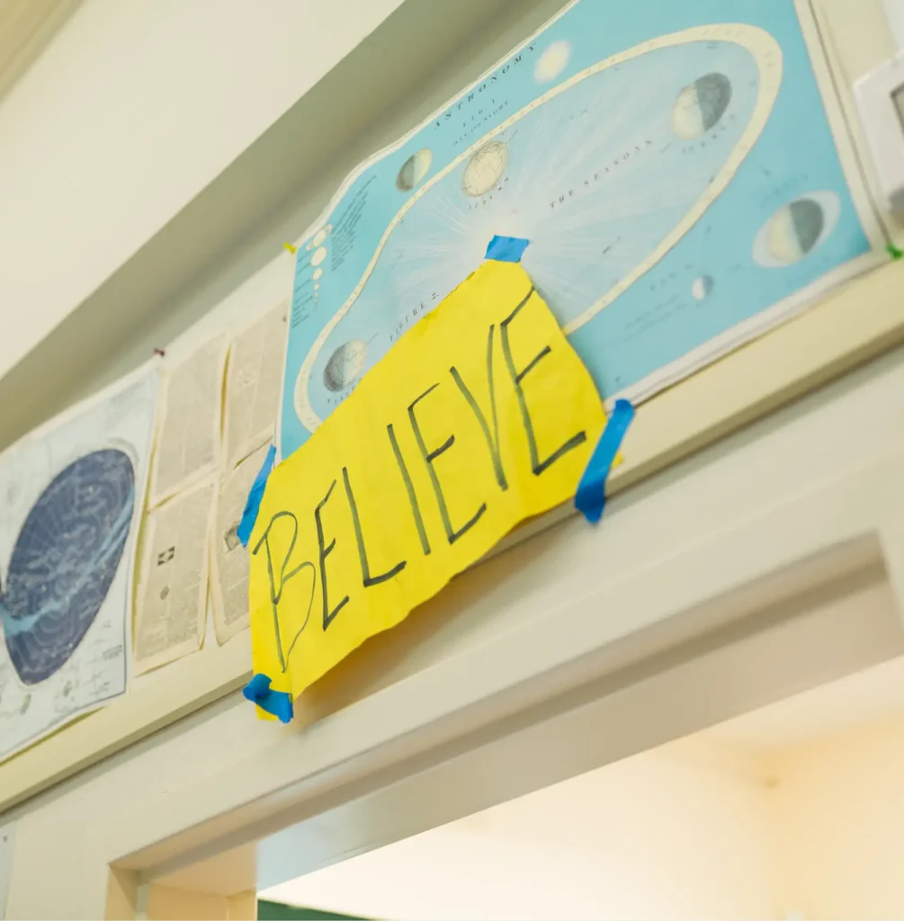 Believe sign taped above doorway
