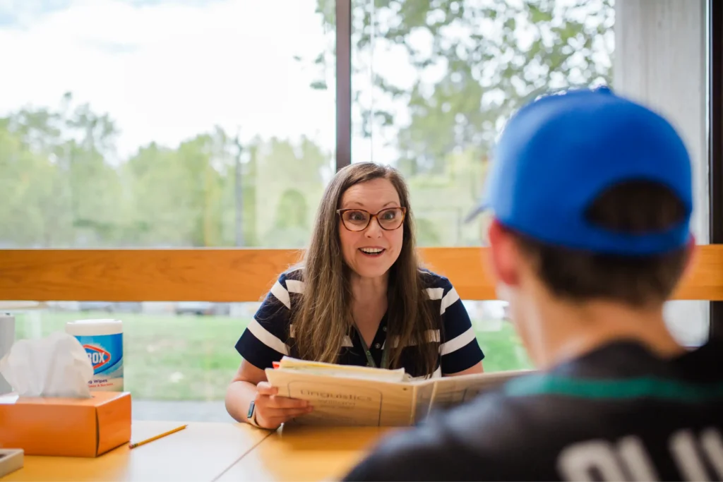 Instructor and student sitting together at table