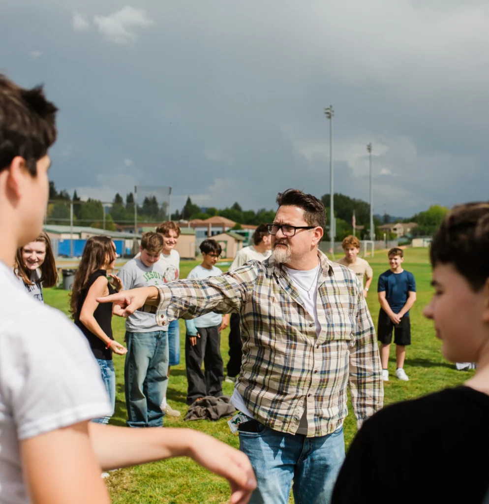 Teacher outside on a field with students