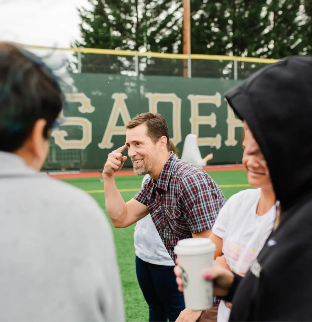 Teacher outside with students pointing to head